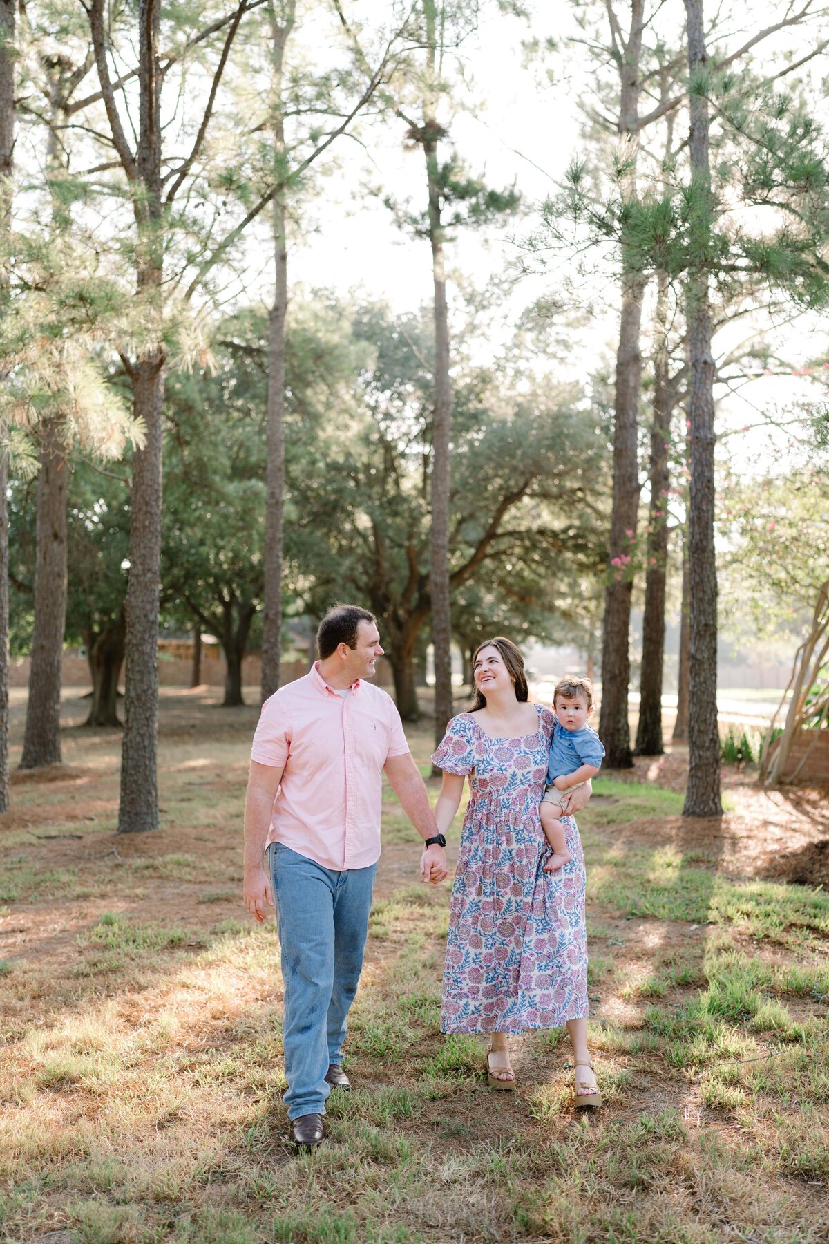 Couple holding baby walking through field
