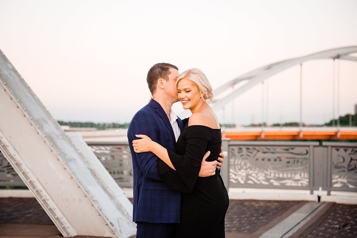 Engaged couple standing together on the John Schneider Bridge