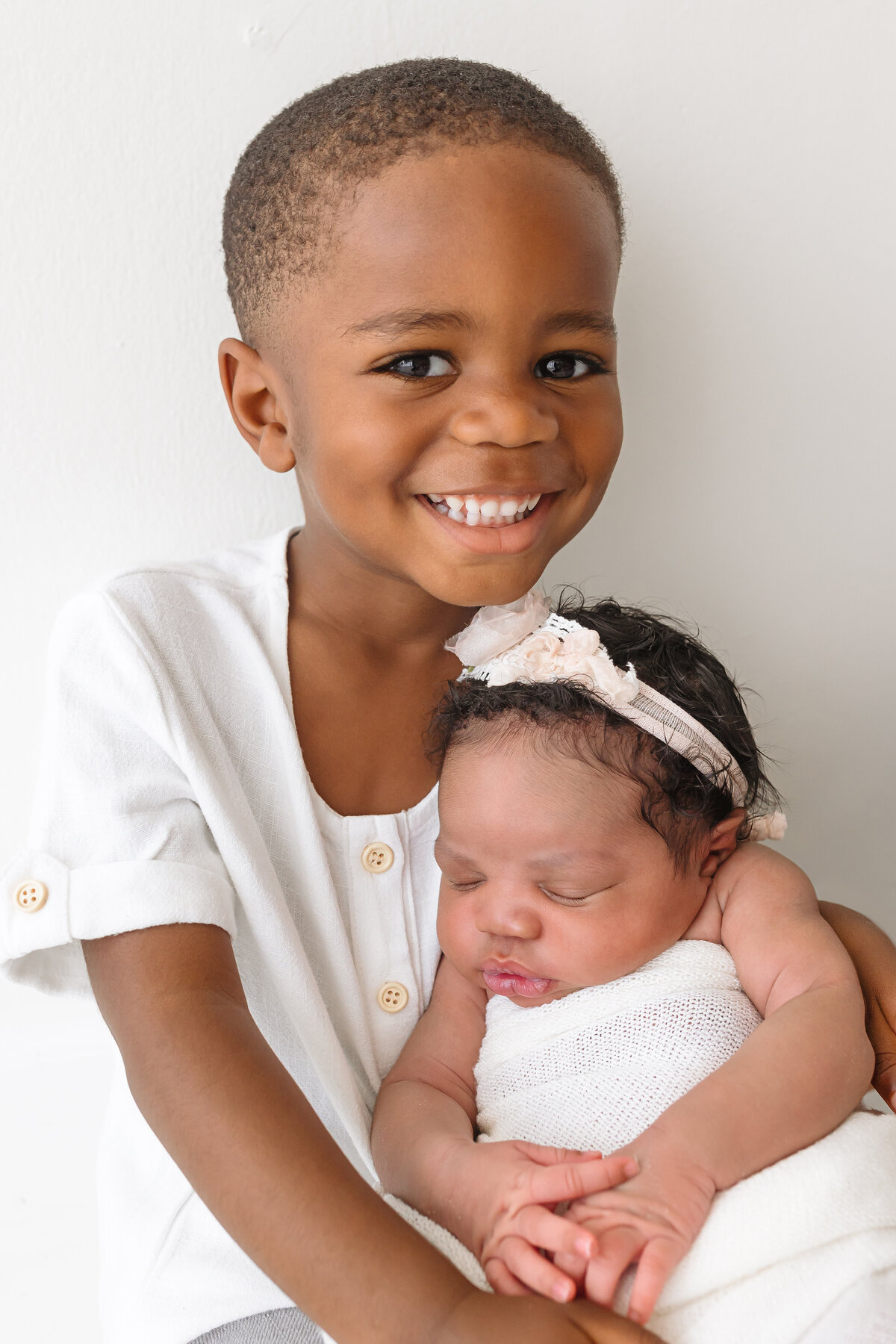 toddler holding newborn baby