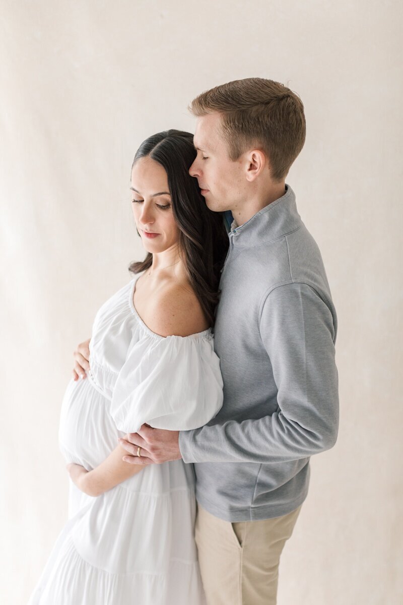 A pregnant woman and her husband stand close together during their Lawrenceville NJ Maternity Photography session