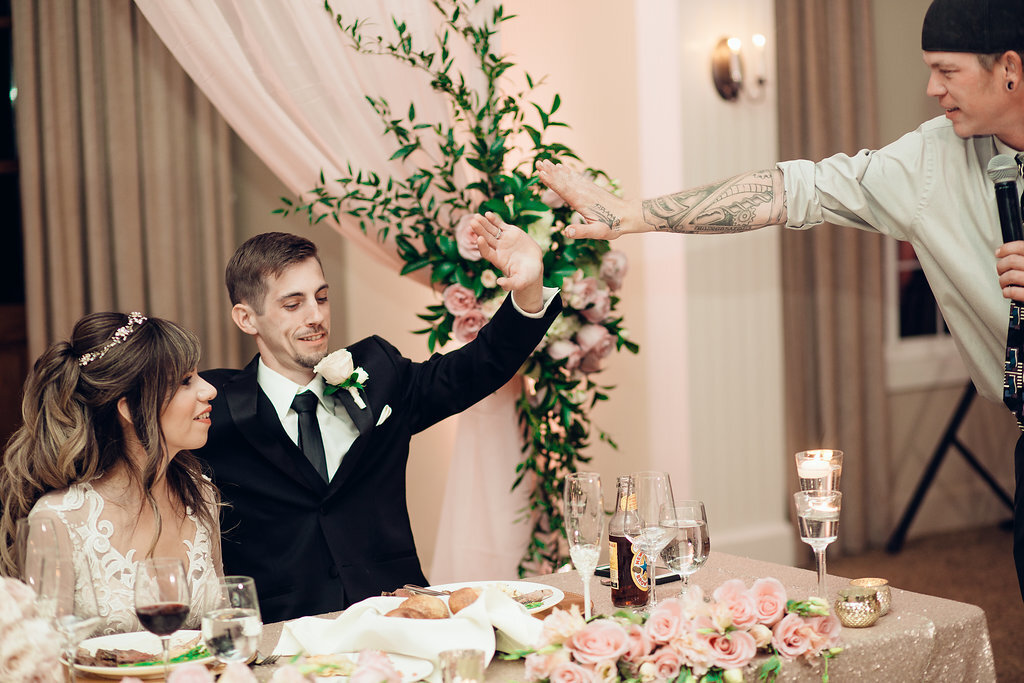 Wedding Photograph Of Groom Having a High Five With Man In White Long Sleeves Los Angeles