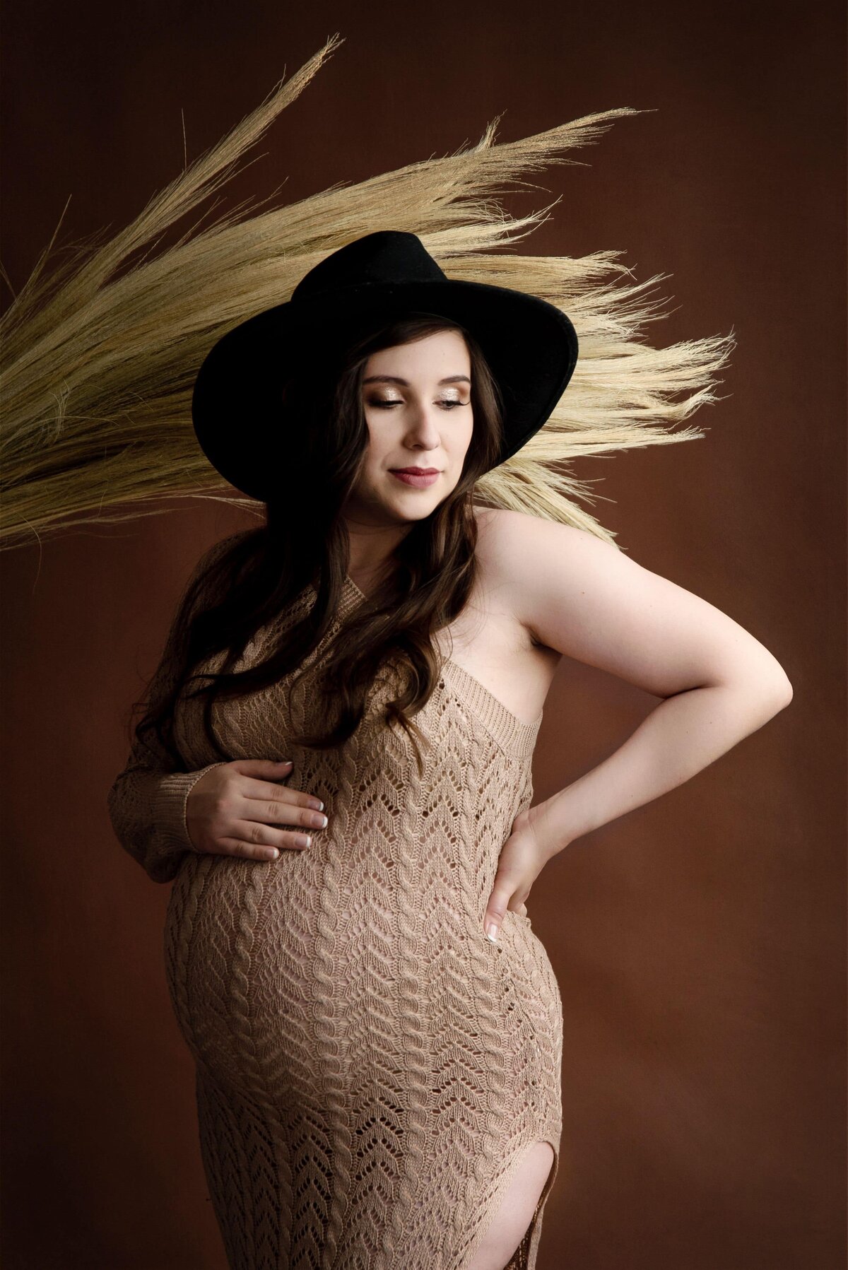 st-louis-maternity-photographer-pregnant-mom-in-sweater-dress-with-black-hat-and-dry-grass-background
