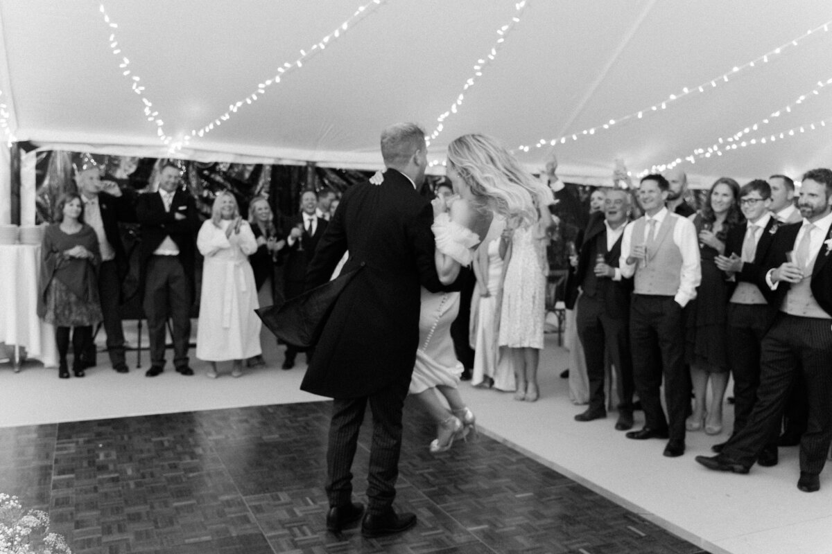 groom spinning the bride during the first dance black and white photo