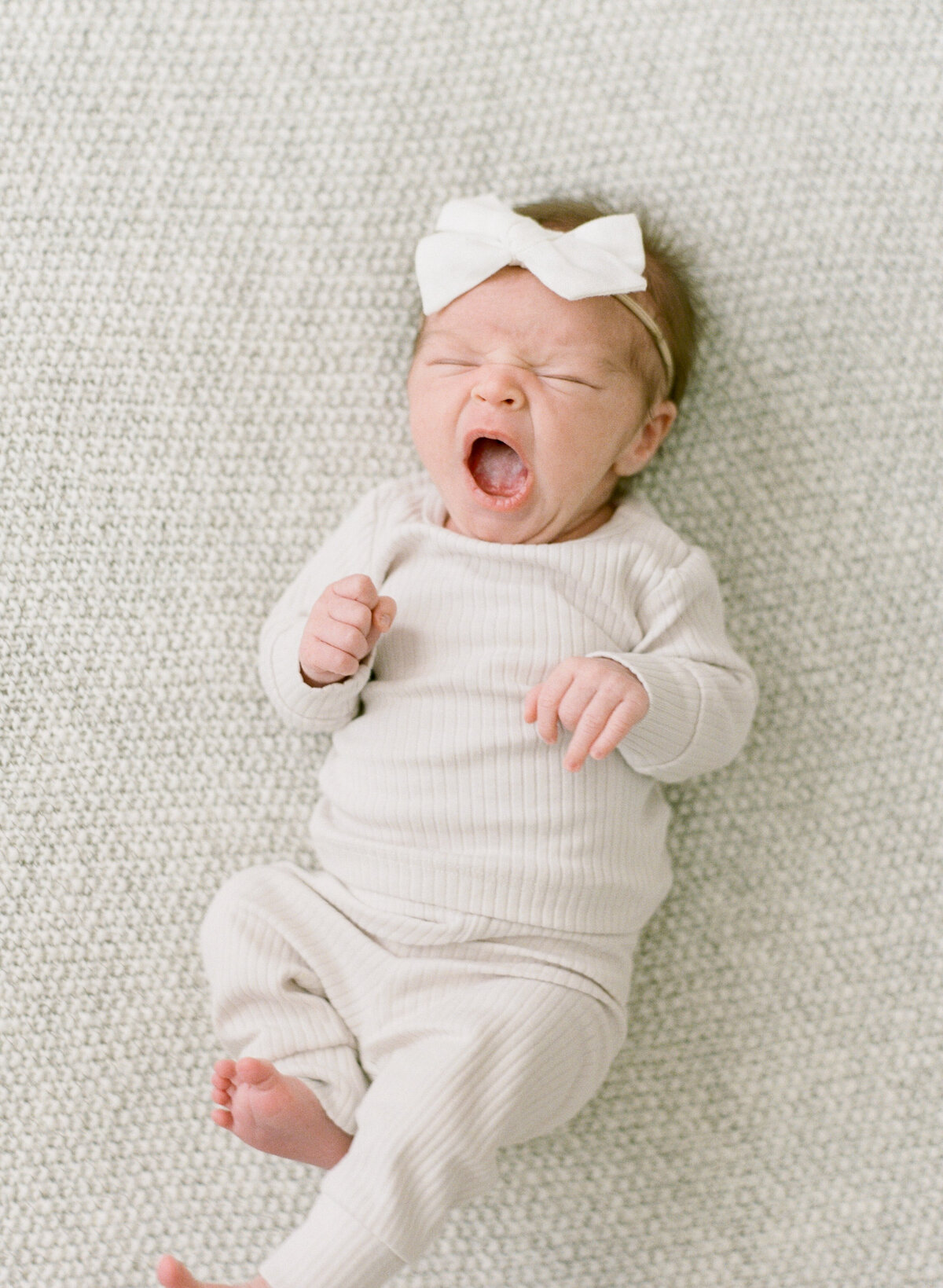 Baby yawns during her newborn session in Raleigh. Photographed by Raleigh Newborn Photographer A.J. Dunlap Photography.