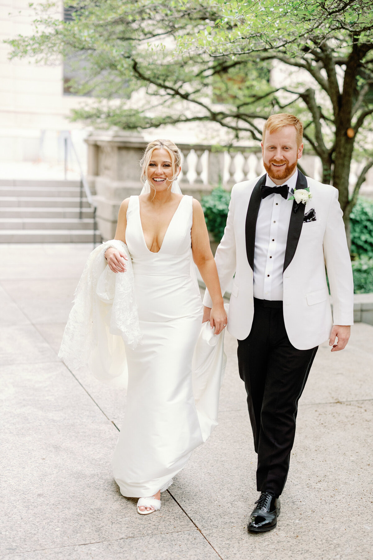 A candid wedding portrait of newlyweds walking through the South Garden of the Art Institute of Chicago