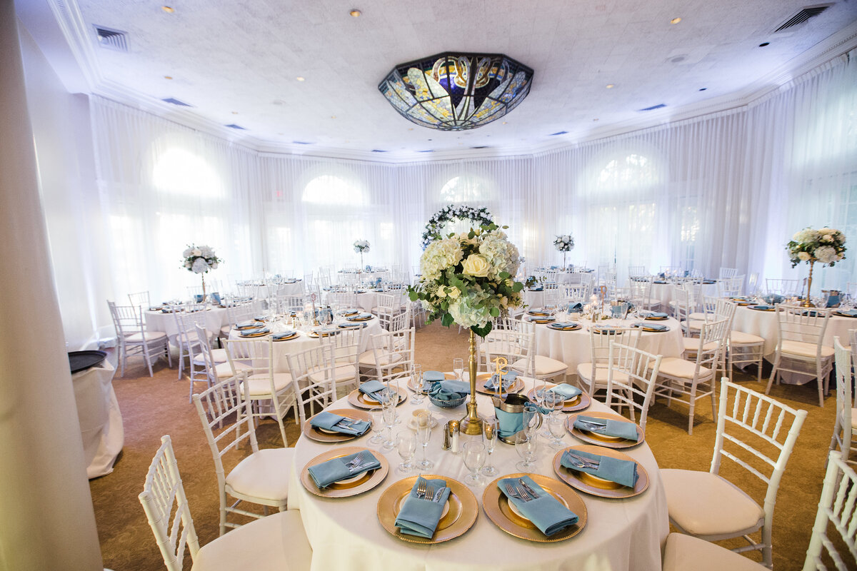 Soft sunlight peeks through the drapes as the guest tables are captured moments before the reception is to begin.