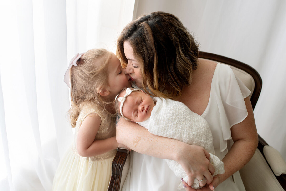 Newborn session of baby girl with older sister and mother