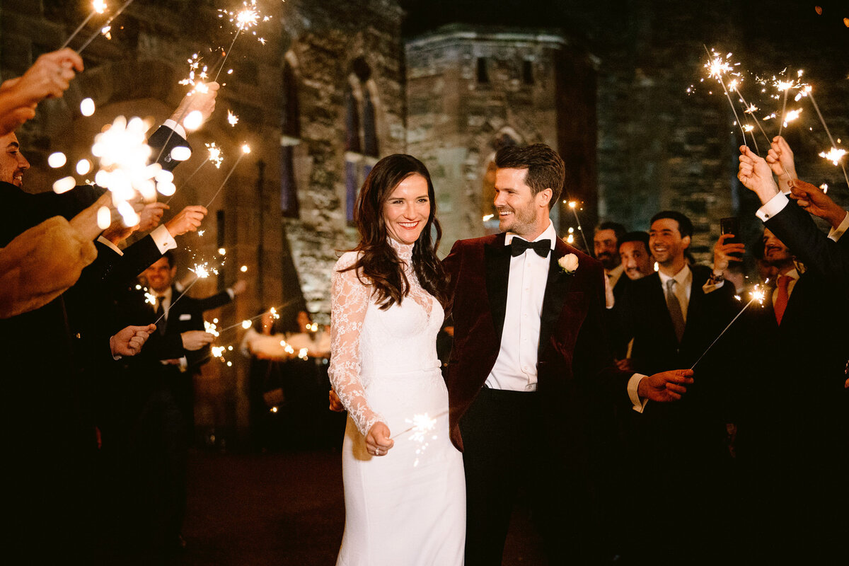 couple exiting peckforton castle to sparklers