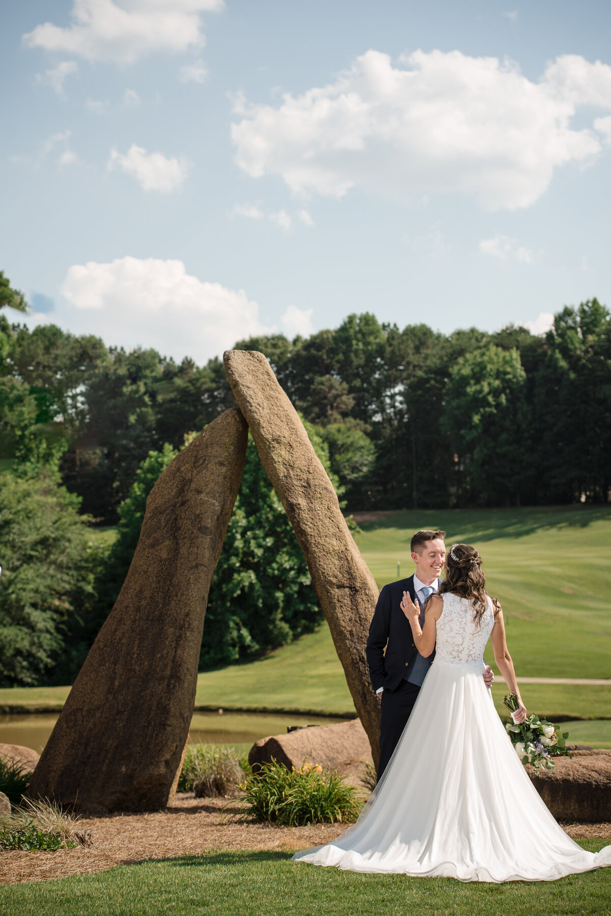 Bride-and-groom-posed-next-to-the-stone-sculpture-on-the-golf-course-of-NorthStone-Country-Club