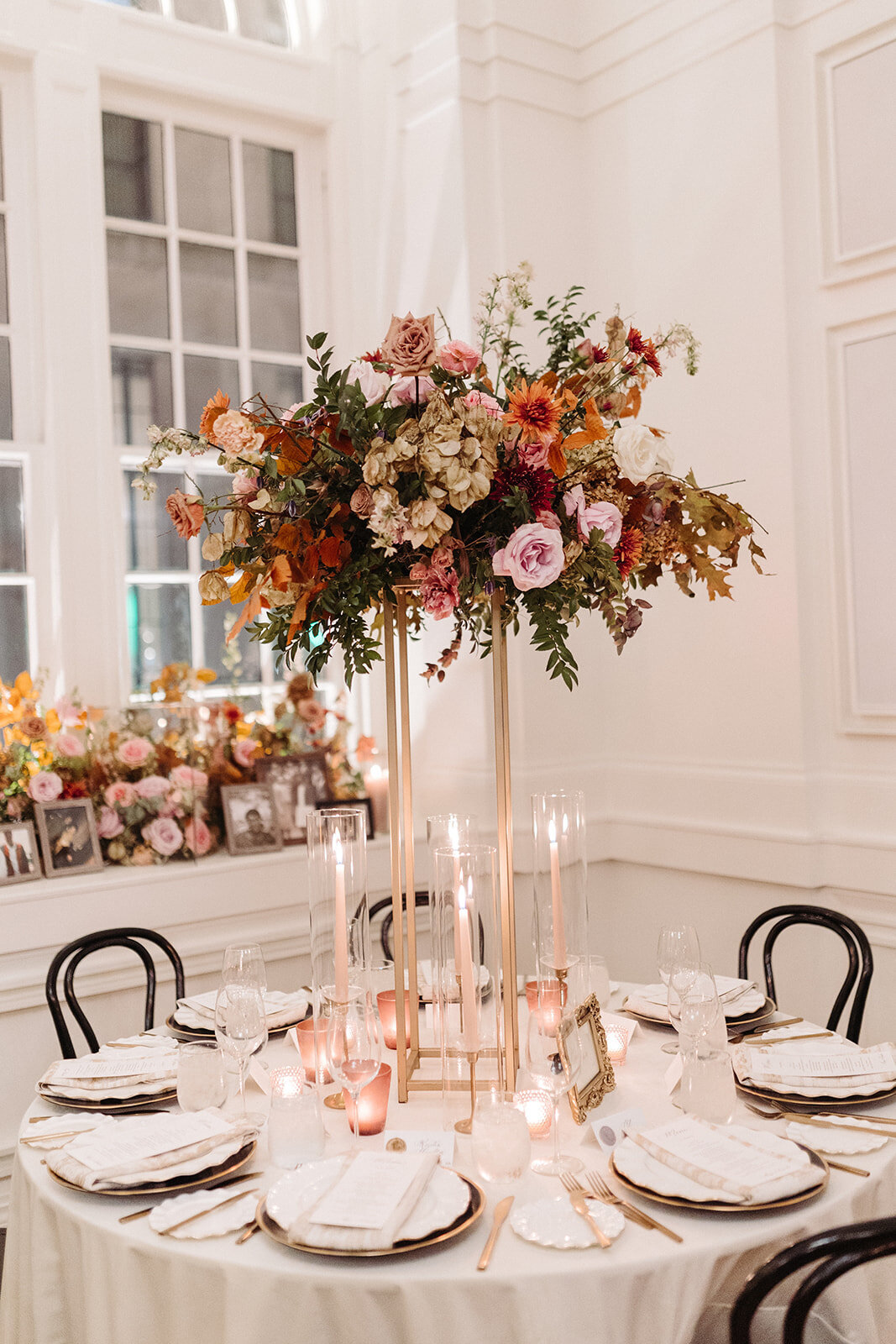 Lush floral meadows surround the cake at this Parisian inspired fall wedding with hues of dusty rose, terra cotta, mauve, copper, and lavender composed of roses, ranunculus, copper beech, clematis, and fall foliage. Design by Rosemary and Finch in Nashville, TN.