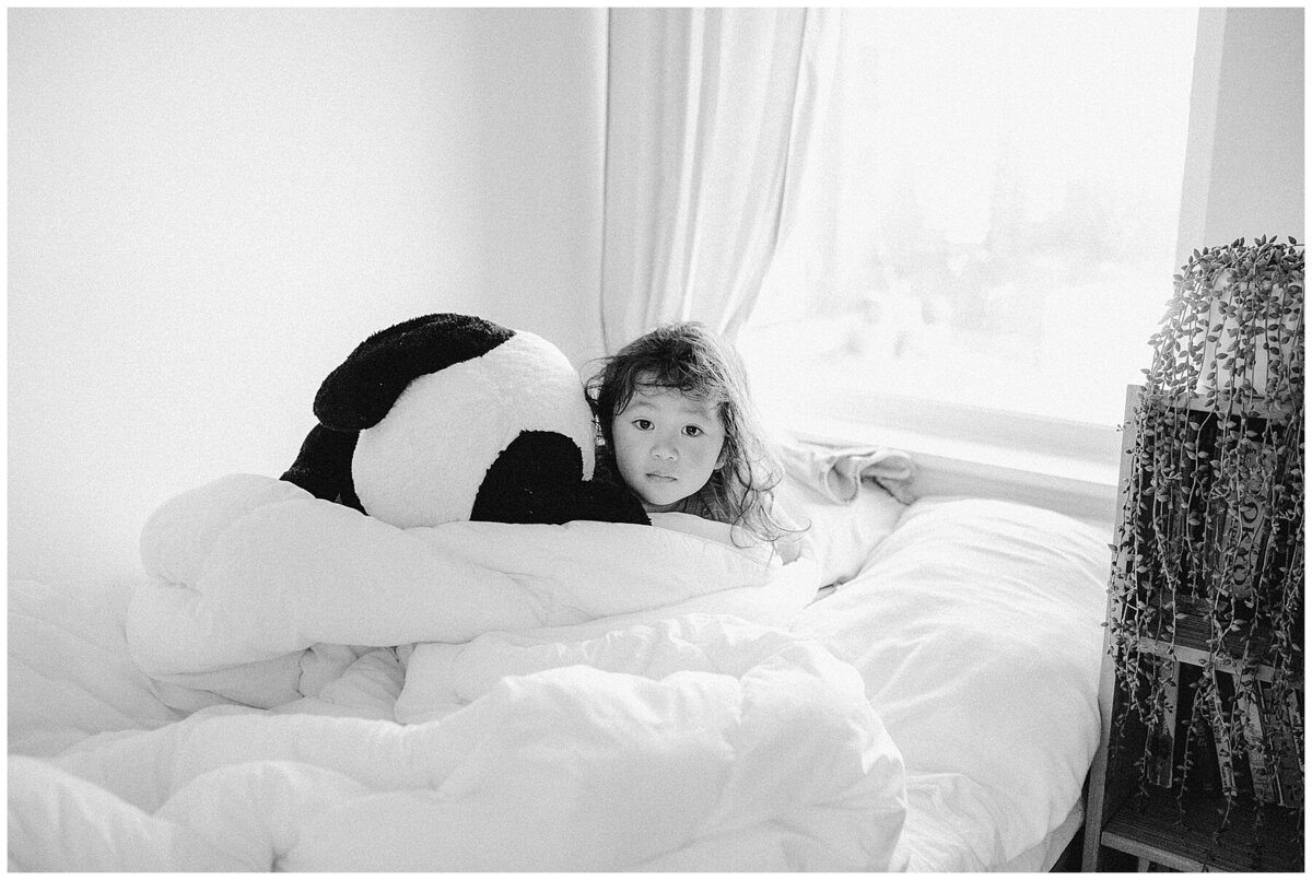Child in bed with giant stuffed animal