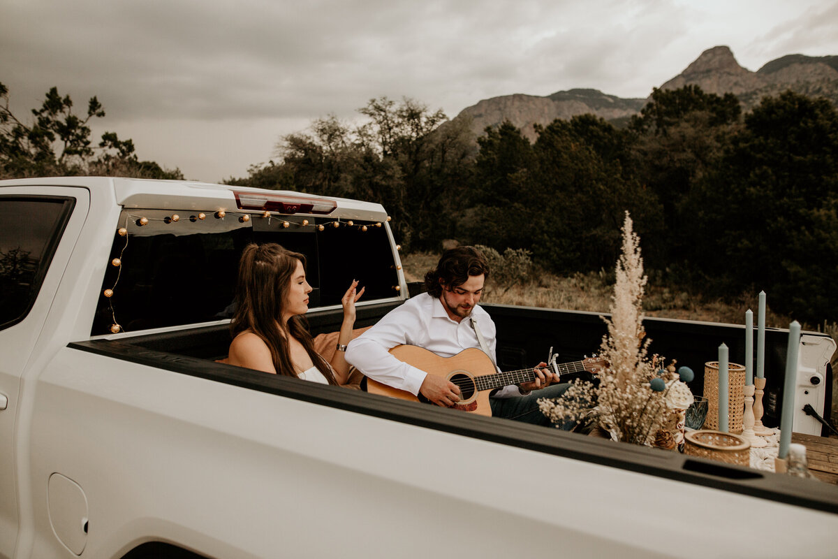 groom playing guitar for bride in their truck bed in Albuquerque