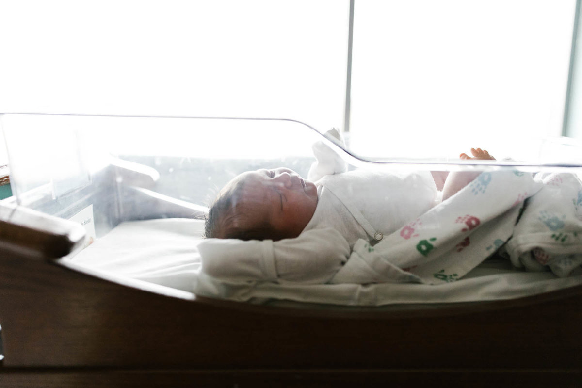 One day old baby laying in bassinet at the hospital by Elle Baker Photography
