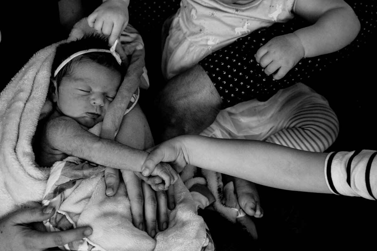 Newborn holding brother hands during family session Coaticook Quebec