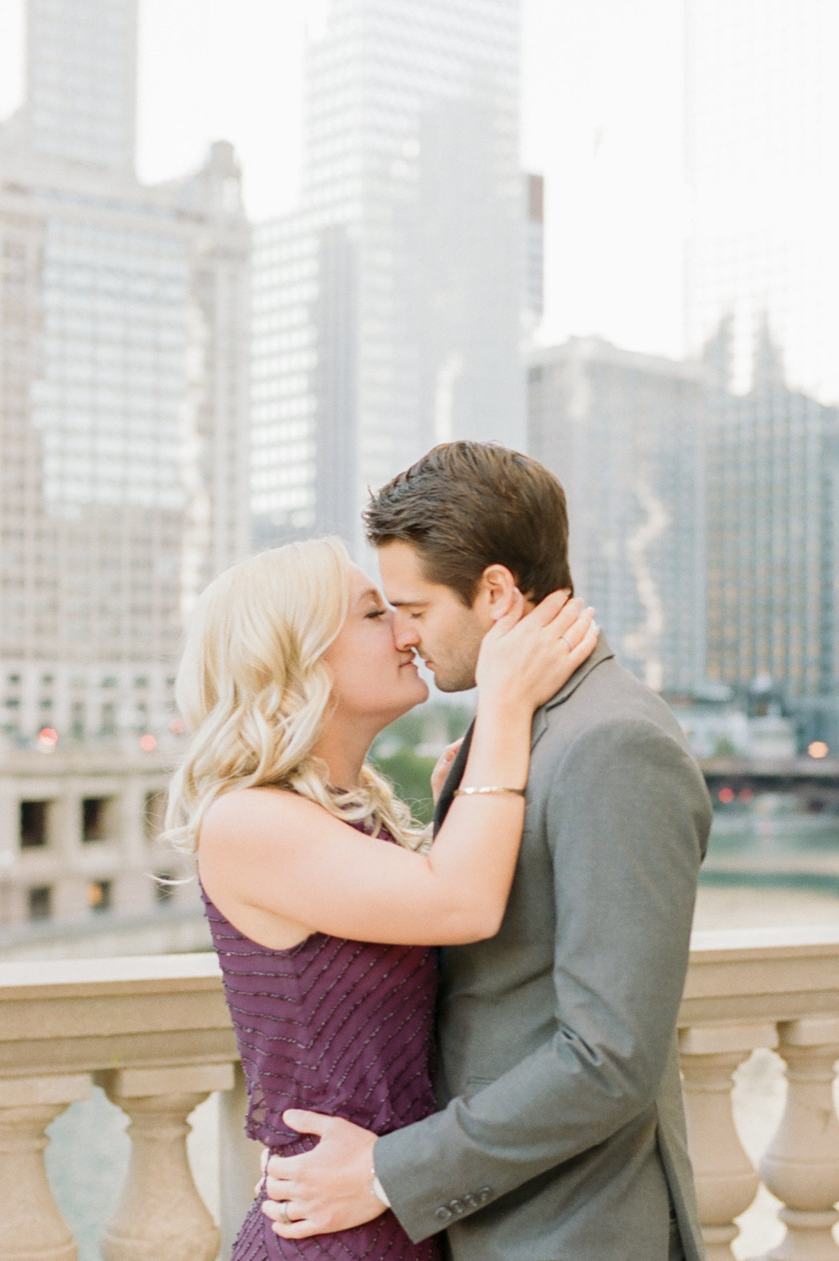 engaged couple kissing in front of chicago skyline