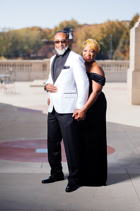 a couple embrace during their engagement photoshoot  at millennium gate museum
