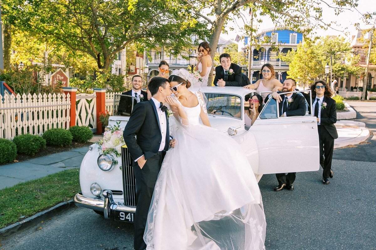 Bride and groom with wedding party on old classic car