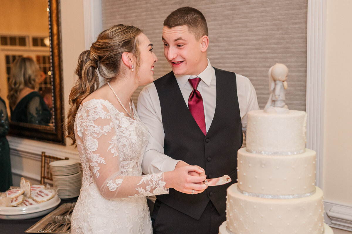 A newly wed couple cutting the cake at The Hudson Manor enjoying their North Carolina wedding photos