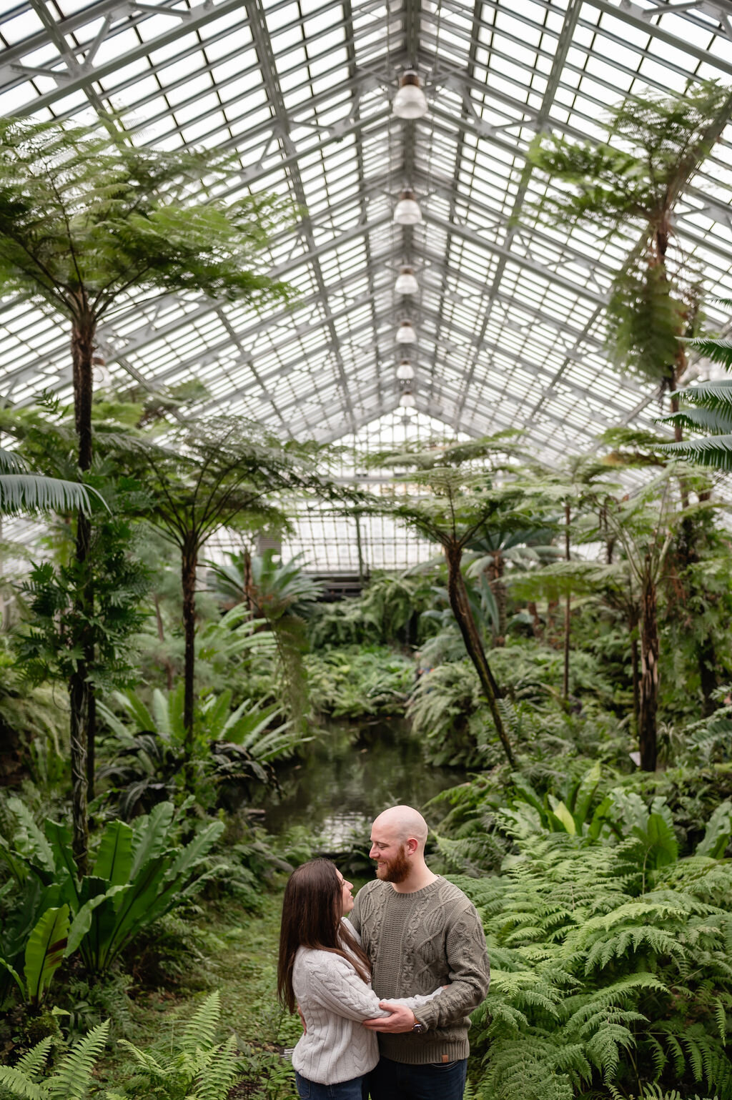 A couple embraces surrounded by greenery at the Garfield Park Conservatory