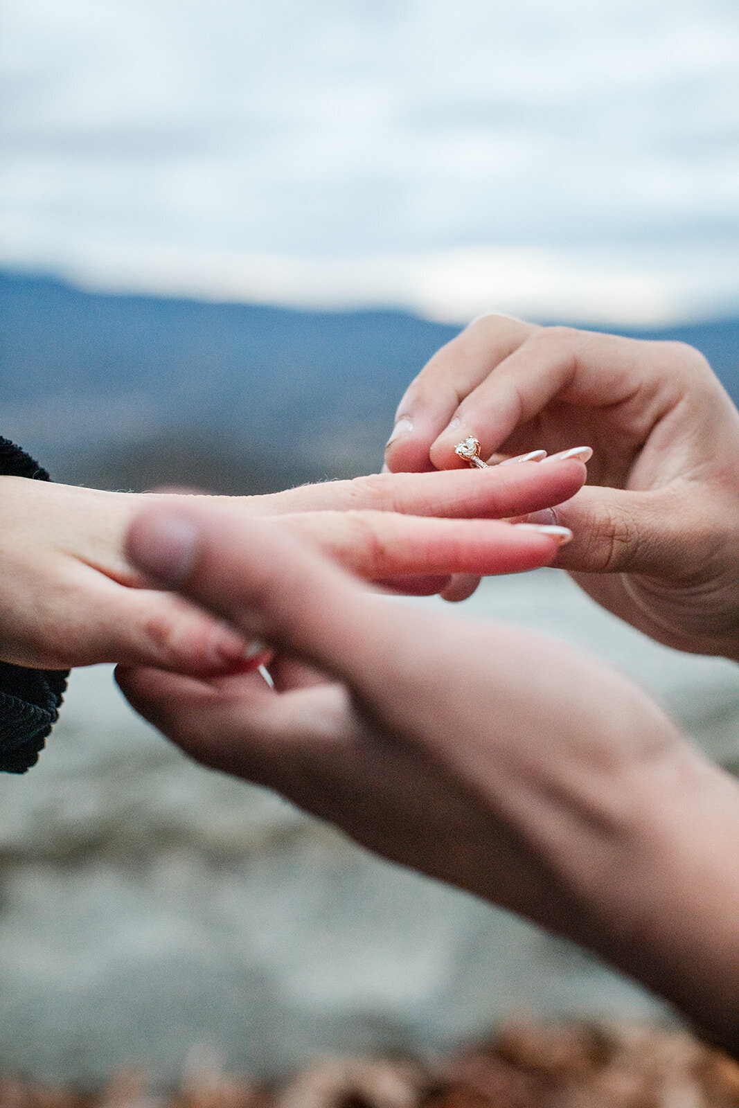 man putting a ring on his girlfriends finger