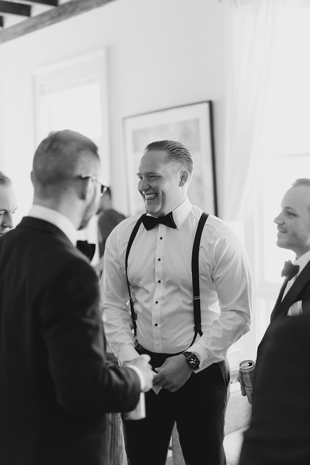 Groom getting ready with the boys in downtown Charleston. Destination Wedding Photographer. Black and white candid wedding photos.