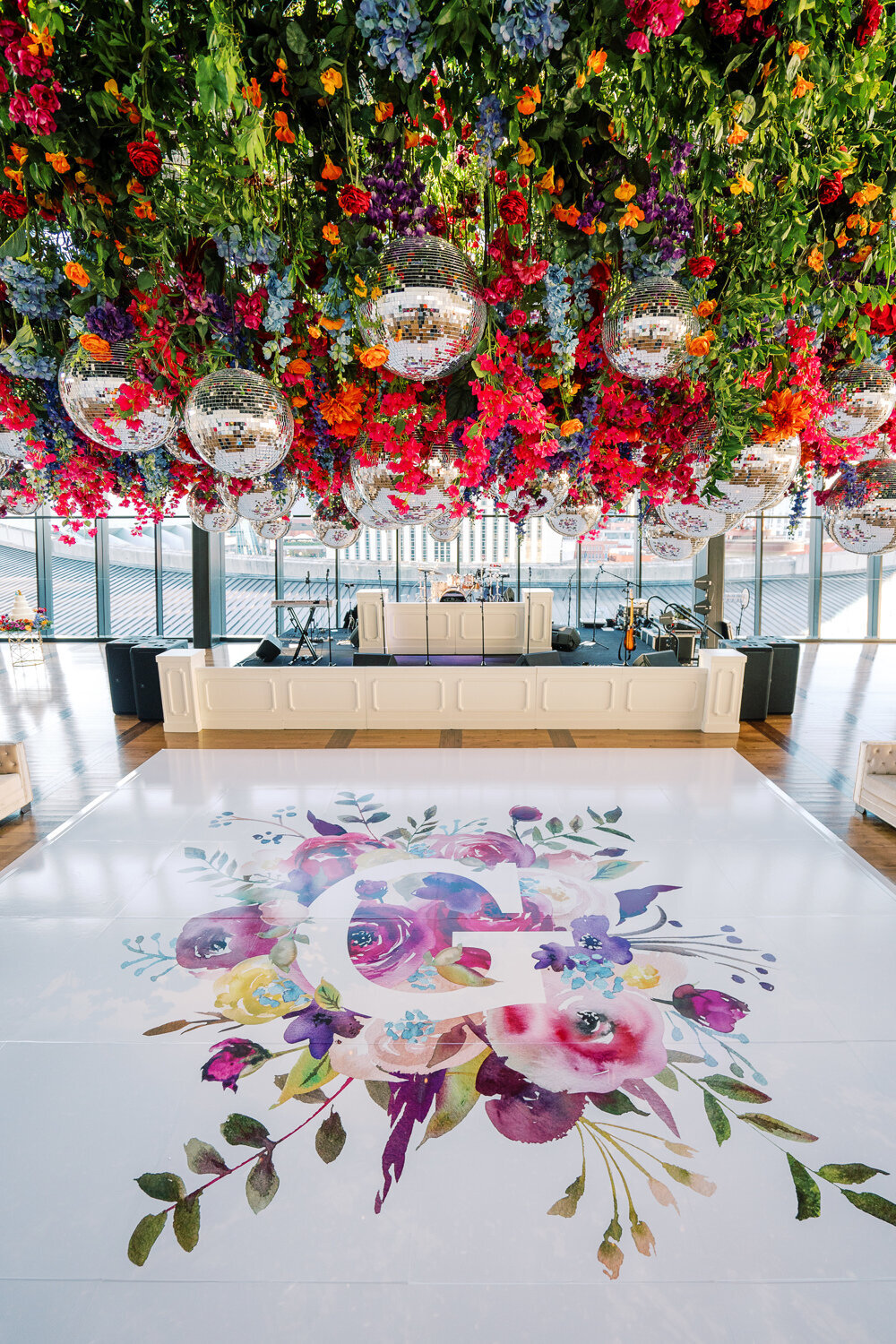 red, blue, yellow, purple flowers and greenery with disco balls hanging from ceiling