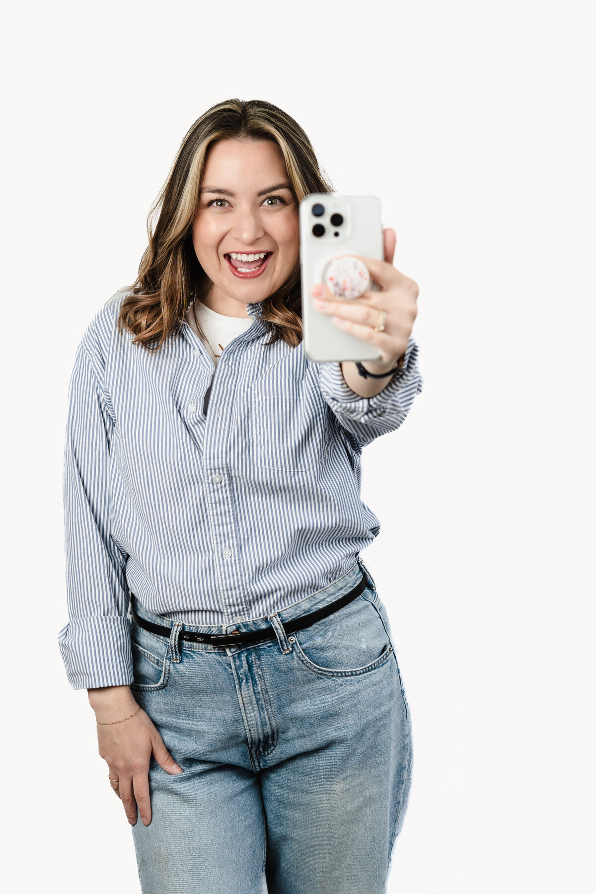 headshot of a Marketing Strategist  and content creator posing with her phone