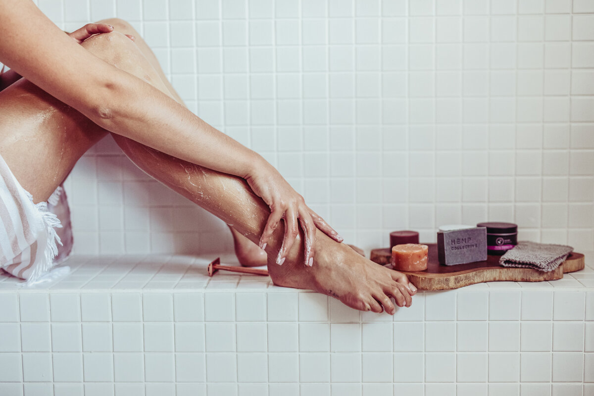 Woman's lower body with hemp skincare products in bathroom