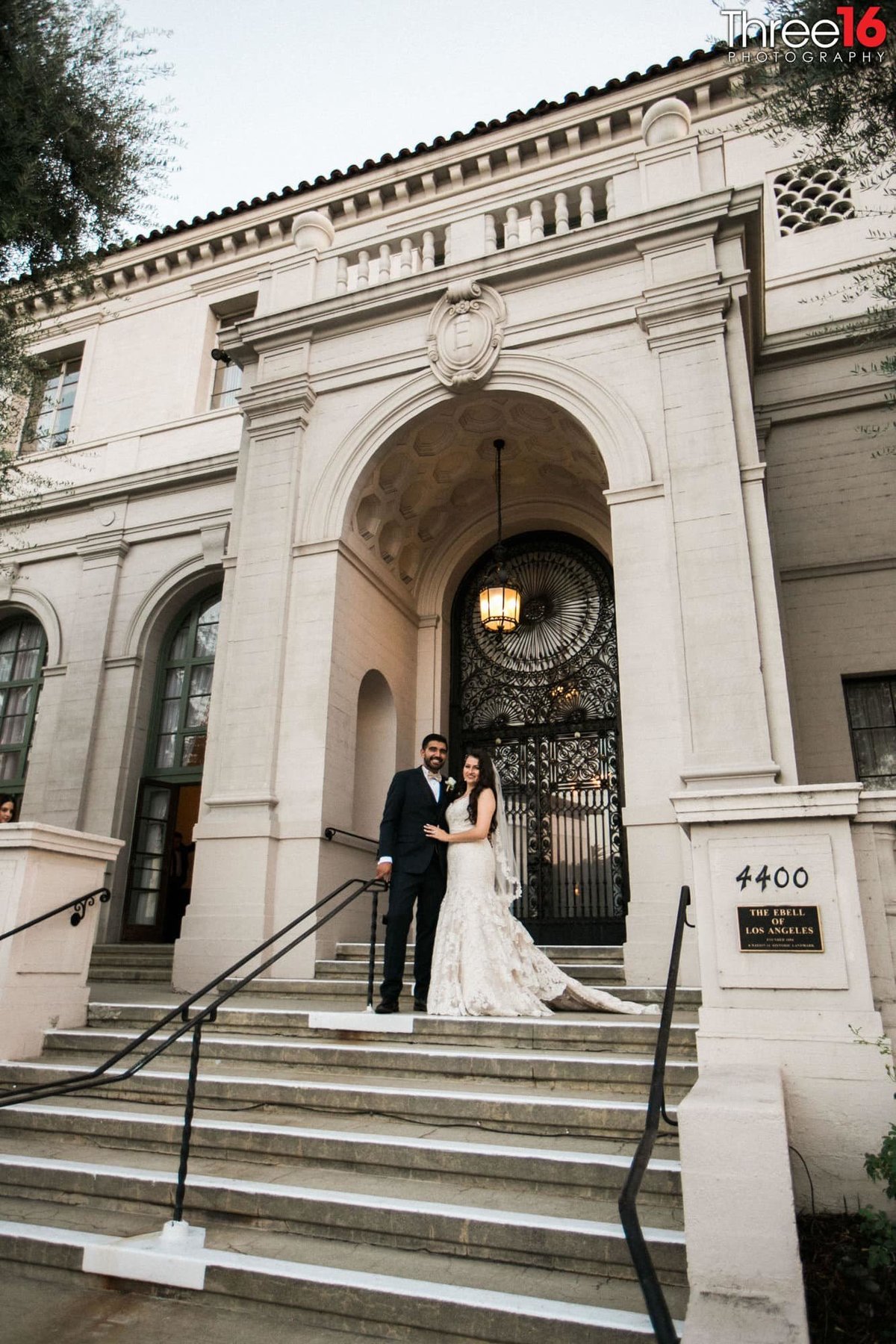 Bride and Groom pose for photos at the entrance to the Ebell LA