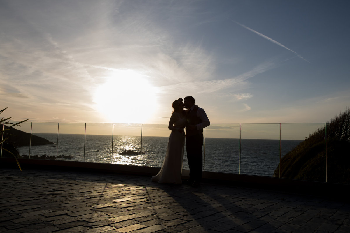Couple kissing on the roof terrace during sunset at Tunnels Beaches