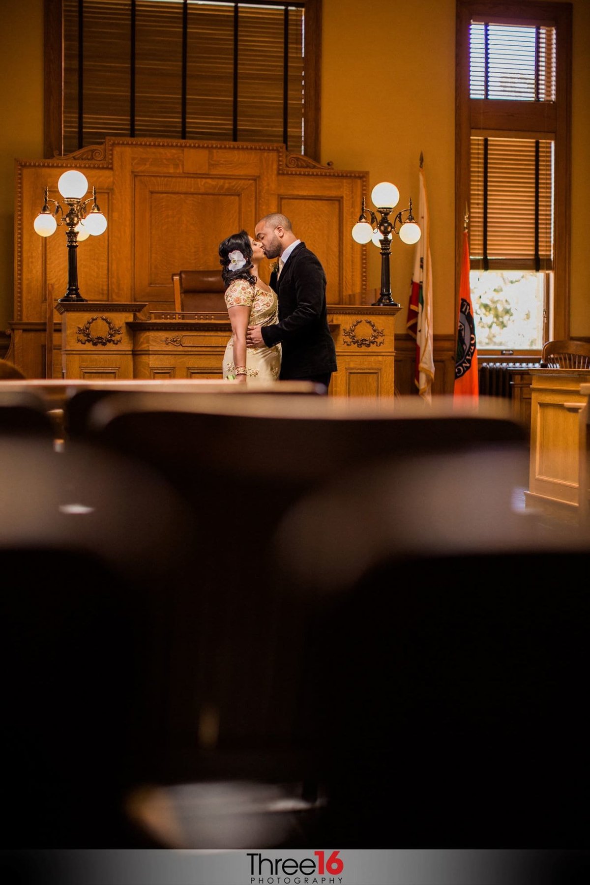 Groom kisses his Bride in front of the Judge's box
