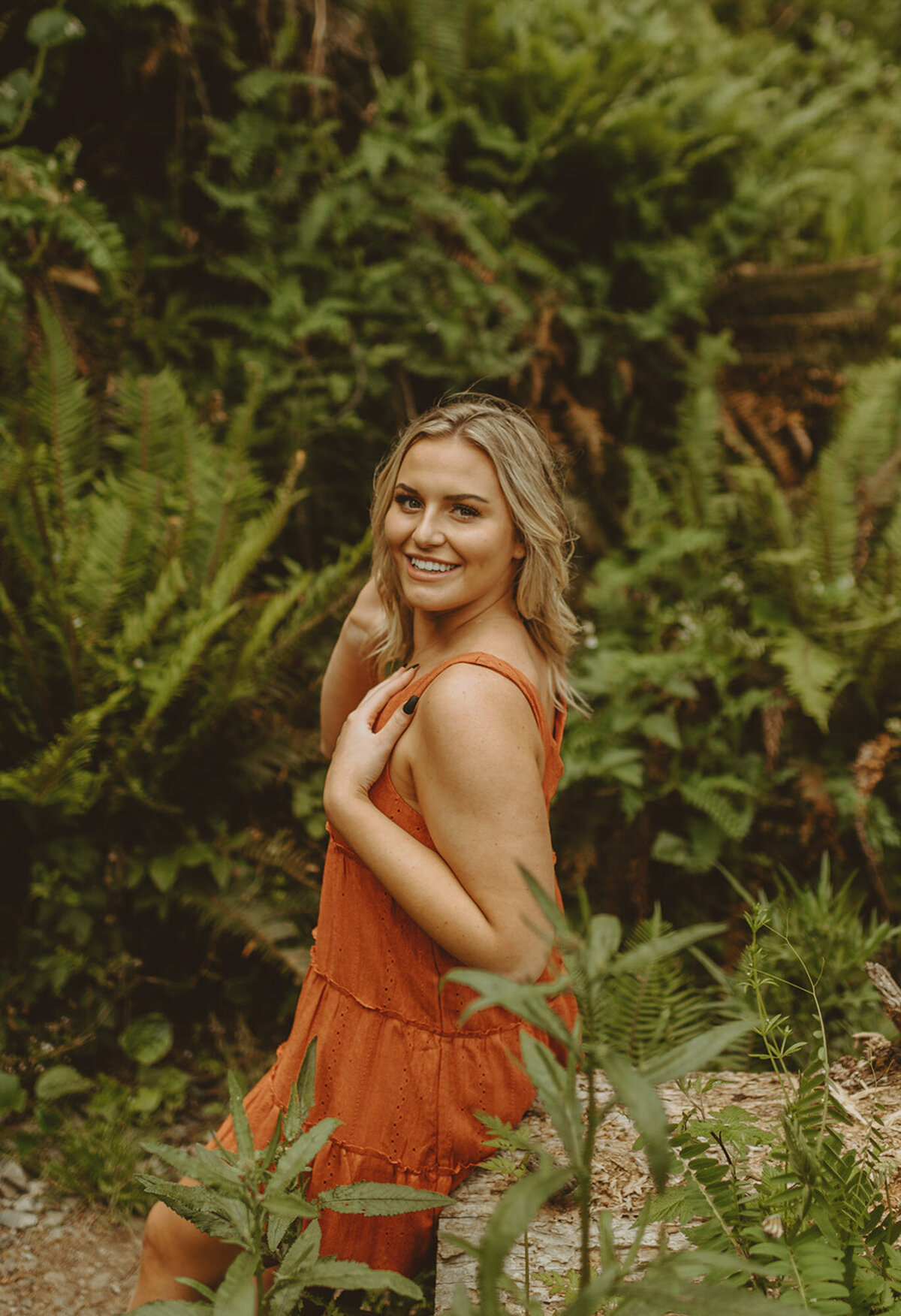 girl in orange dress posing in the forest