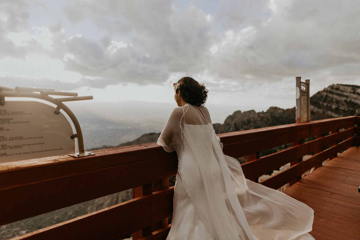 bride looking over ledge at Sandia Peak Tramway down at Albuquerque