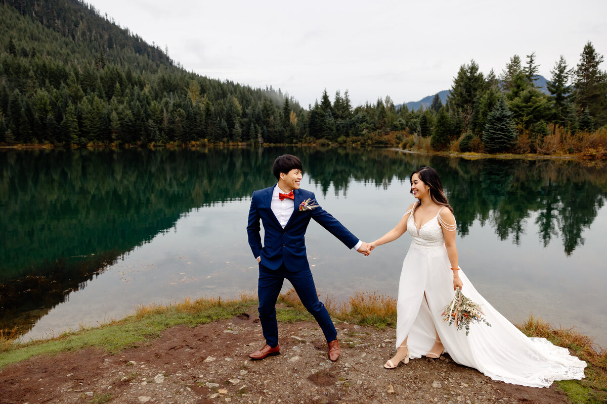 bride and groom walk together at hold creek pond