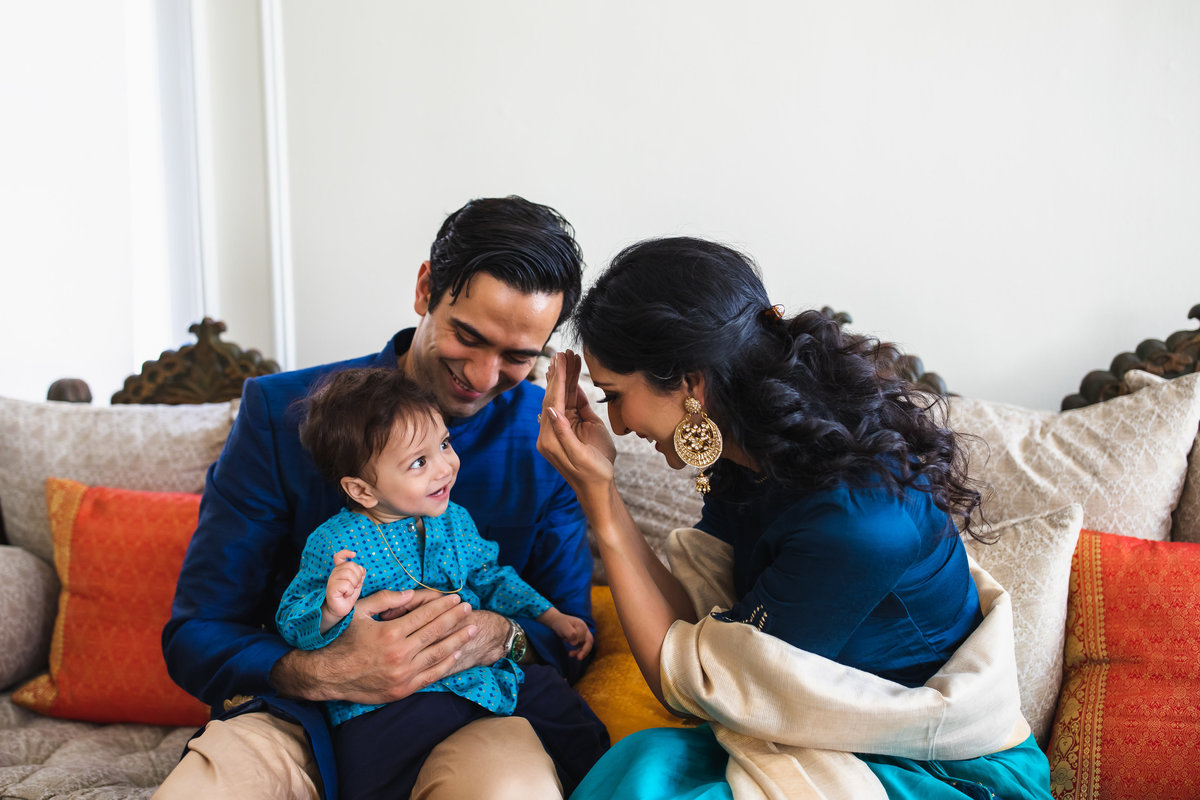 Bay Area family plays peekaboo wearing traditional attire during in home family photography session