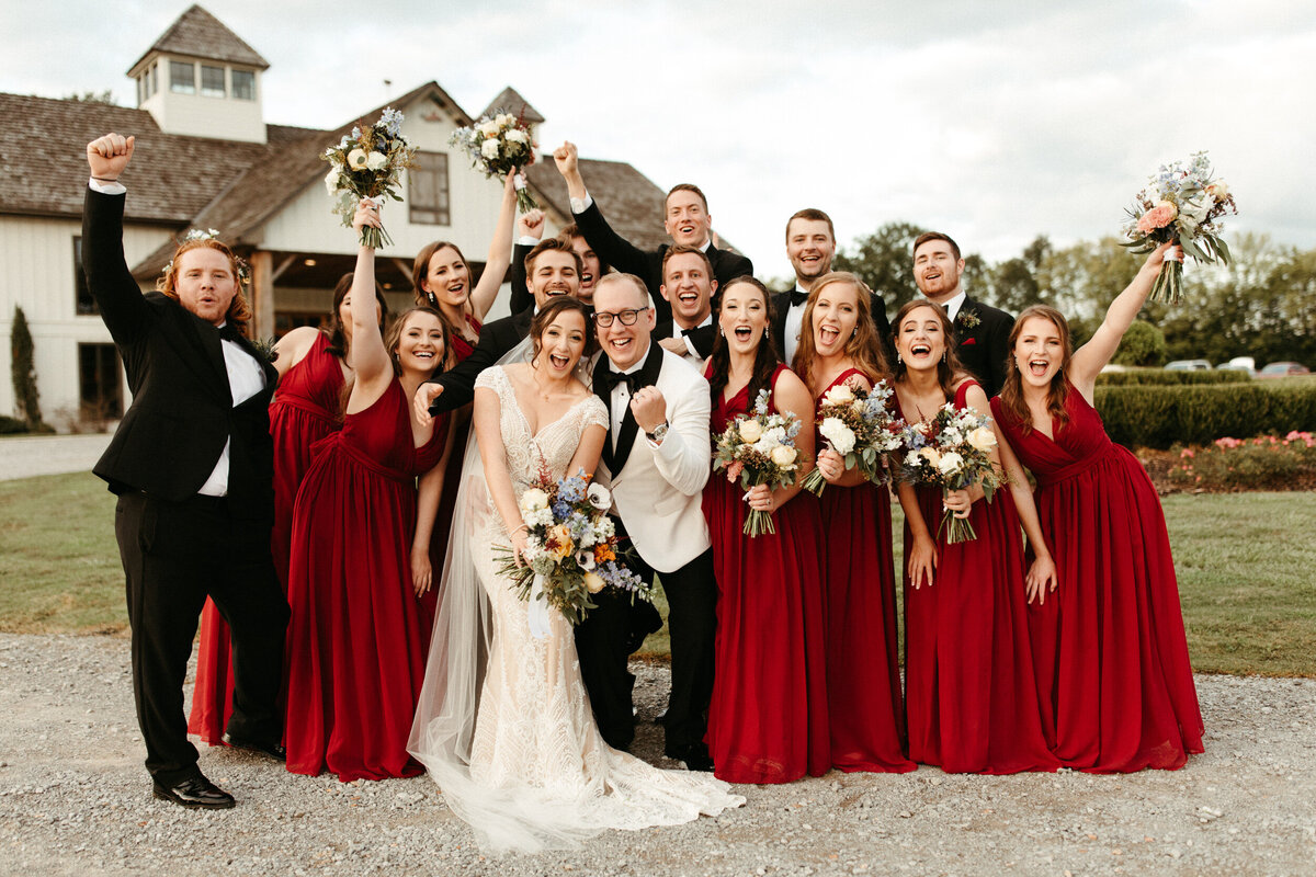 Large bridal party cheering and celebrating with the bride and groom after the wedding ceremony