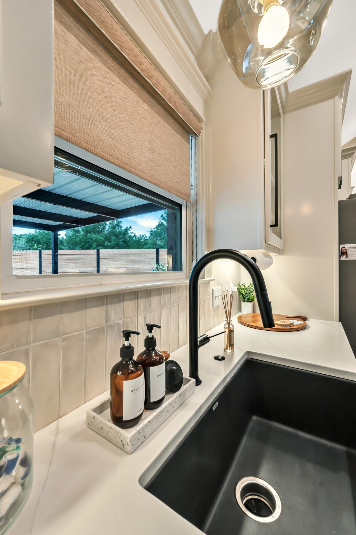 Large kitchen sink with window overlooking the backyard in this three-bedroom, three-bathroom vacation rental home with free wifi, outdoor theater, hot tub, propane grill and private yard in Waco, TX.
