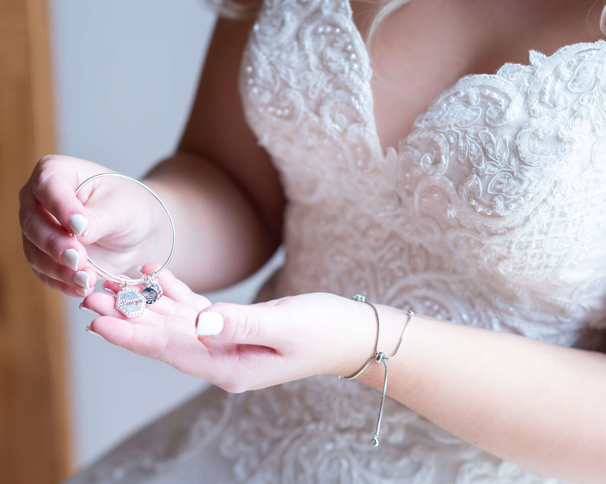 a bride looking at the bracelet her groom gave her on her Ottawa wedding day