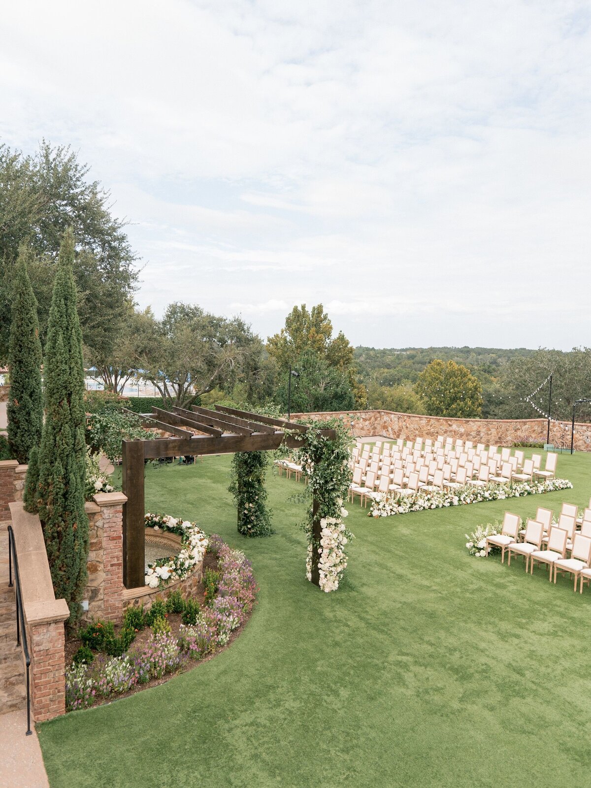 Beautiful outdoor wedding ceremony set up under large pergola