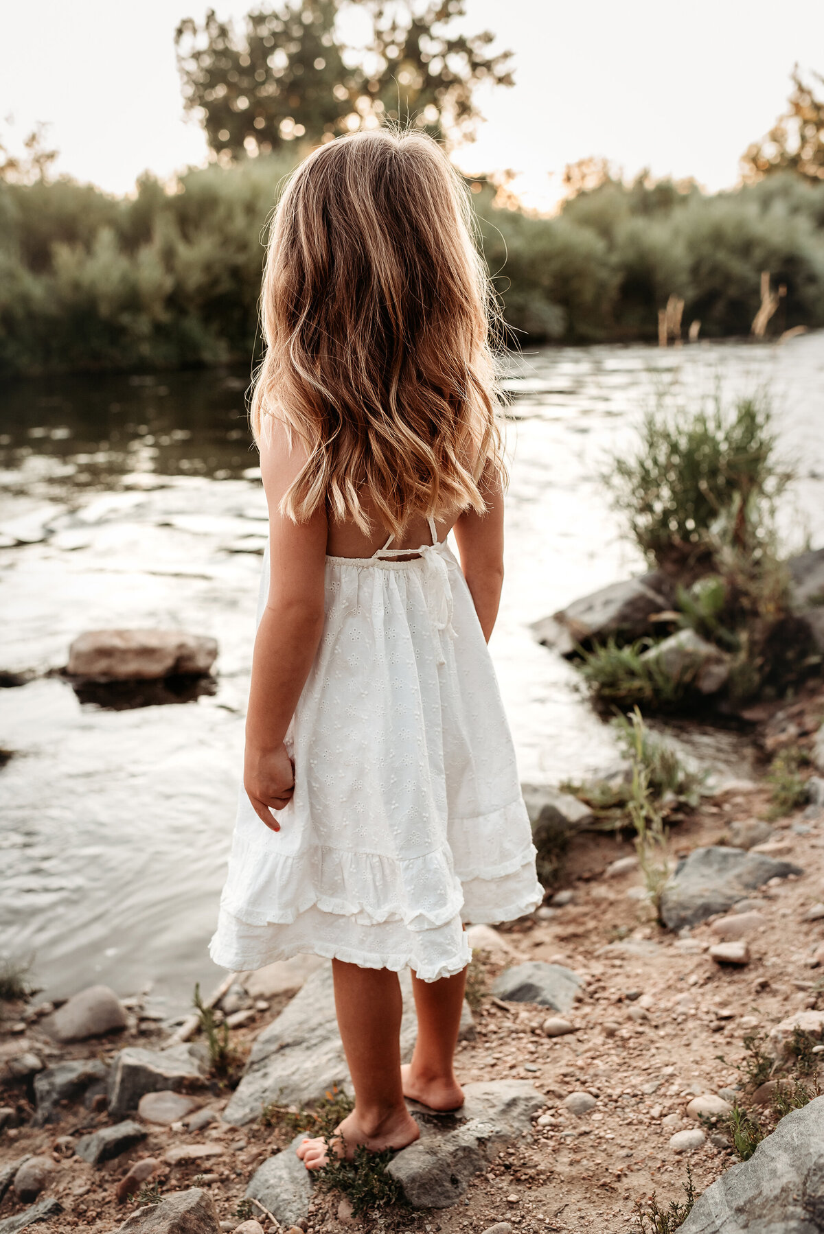 denver family photography rear view of little girl's long hair and white dress at the river