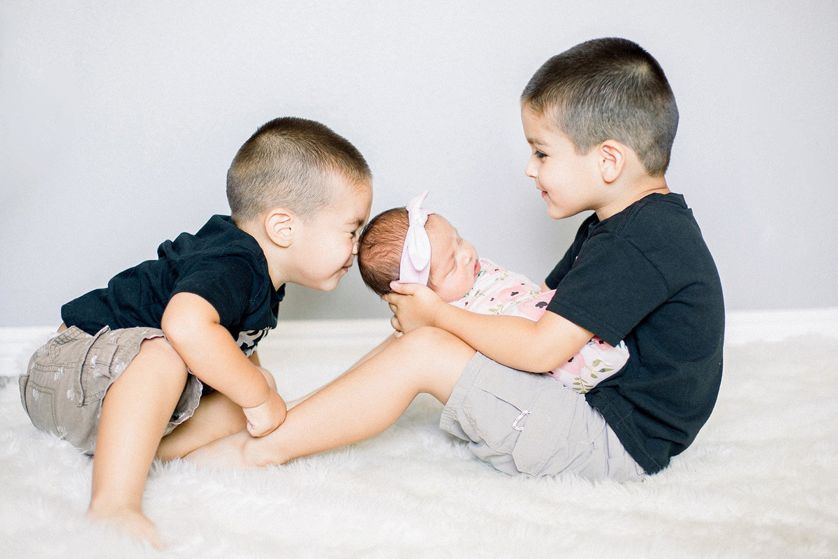 big brothers with their baby sister