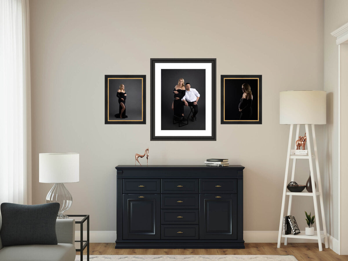 three portraits of a pregnant woman and her spouse hanigng on a wall above a side table
