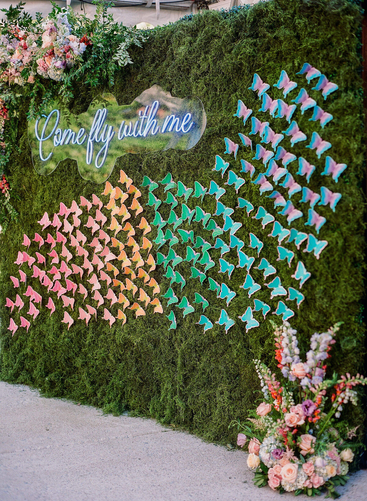Custom escort card wall with colorful butterfly escort cards for table numbers at Saddle Woods Farm.