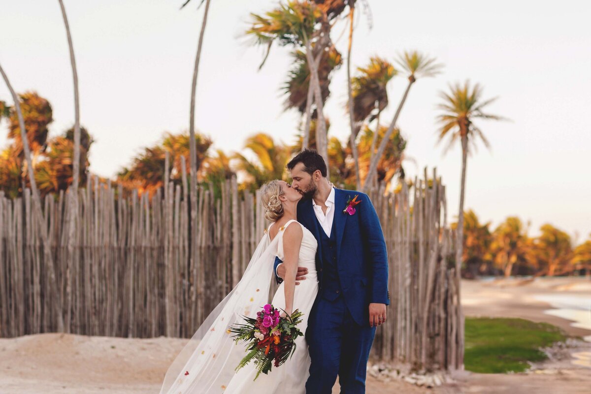 Bride and groom kissing on beach in Riviera maya