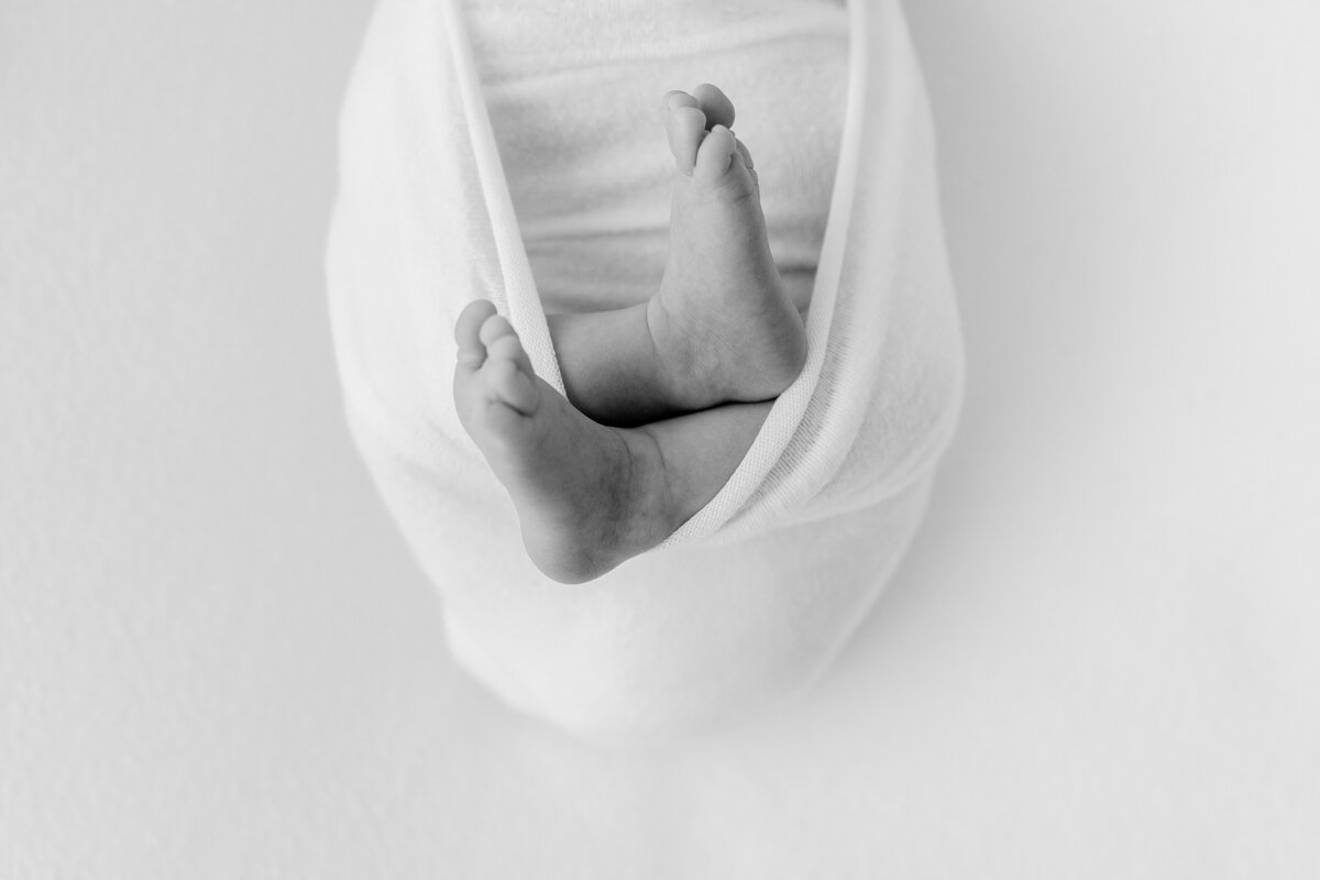 A closeup Northern Virginia Newborn Photography photo of a baby's feet swaddled in a white blanket