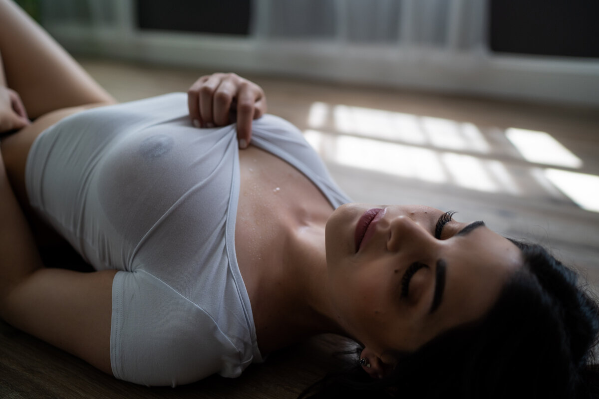 woman puling on her white tee shirt posing for her rhode island boudoir session