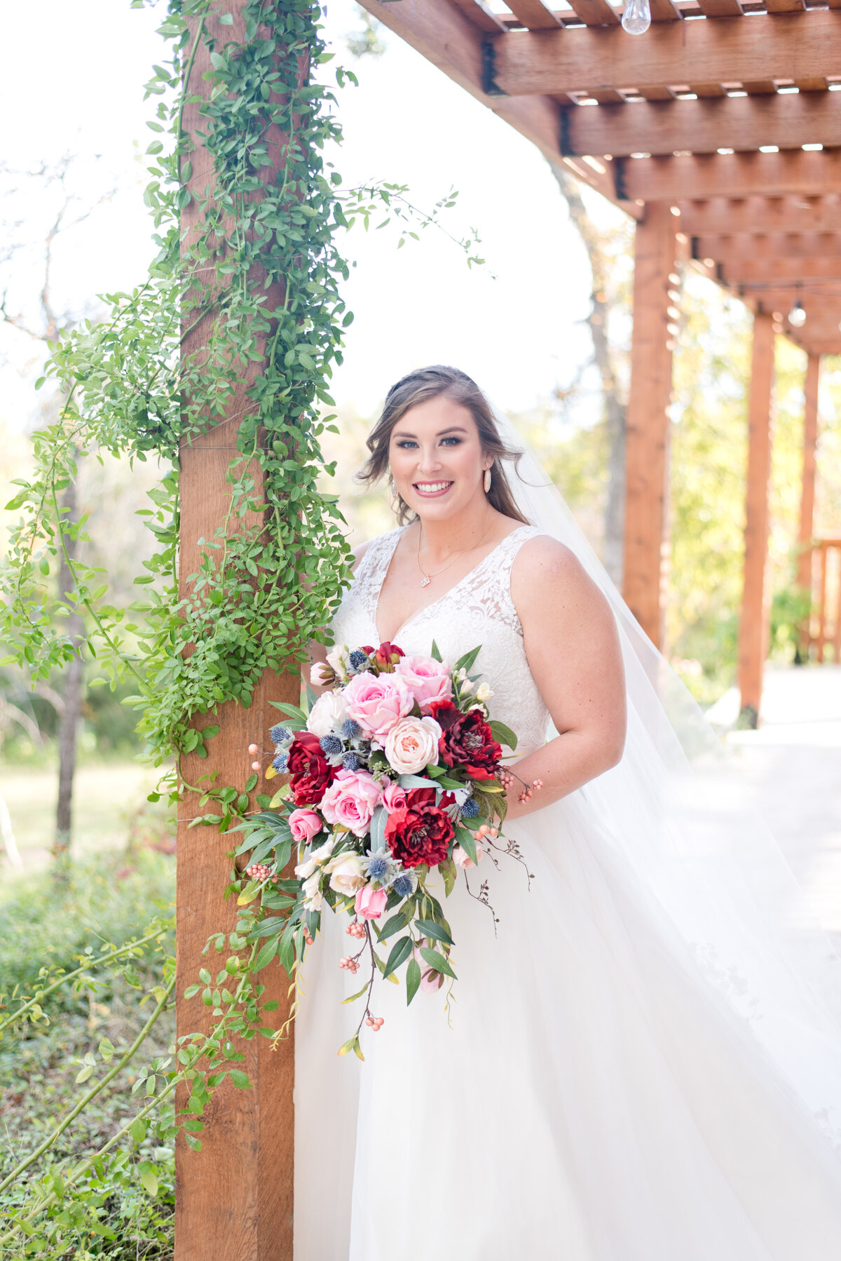Bride standing outside Fort Worth wedding venue with bold colorful flower bouquet