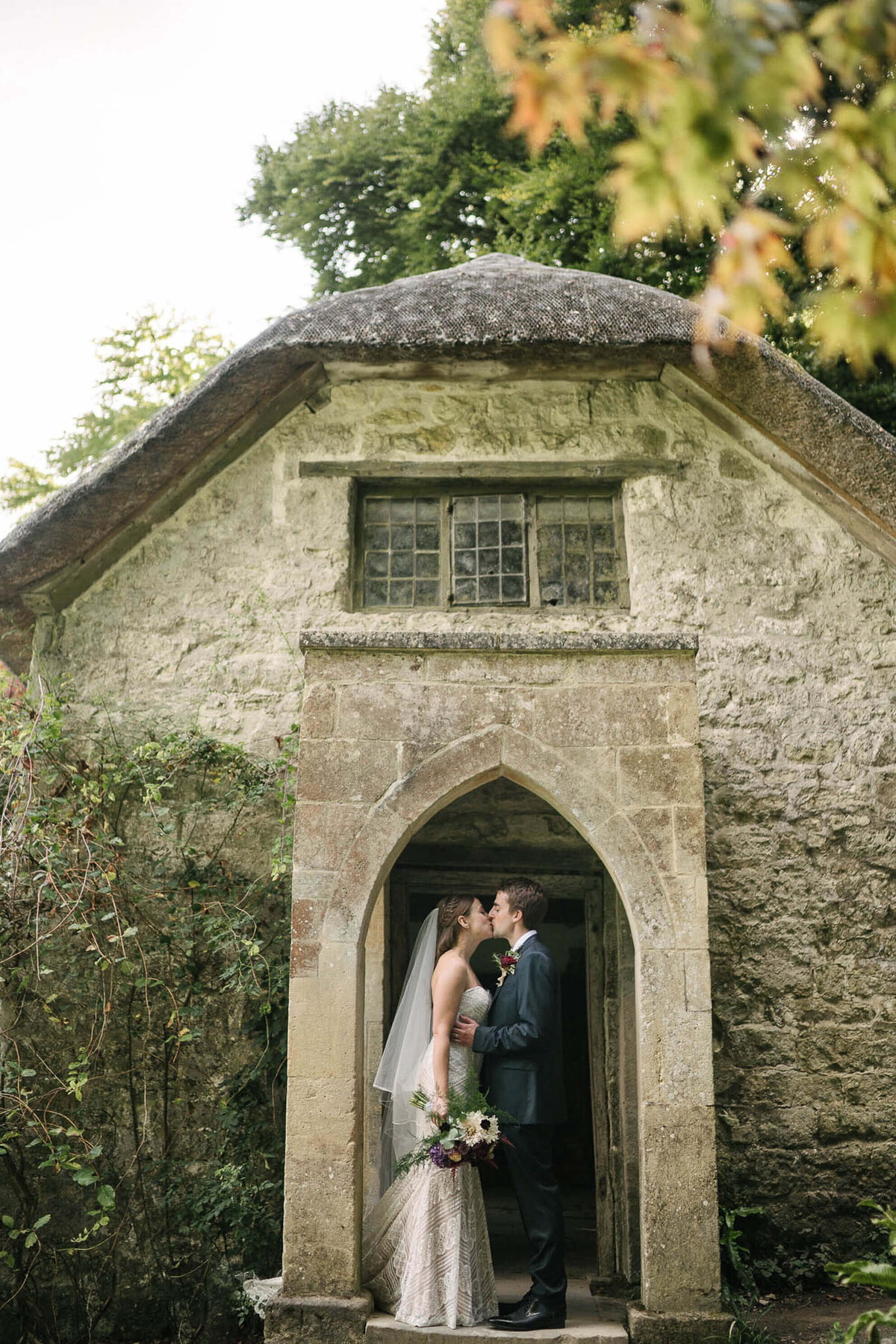 A bride and groom kissing in a doorway