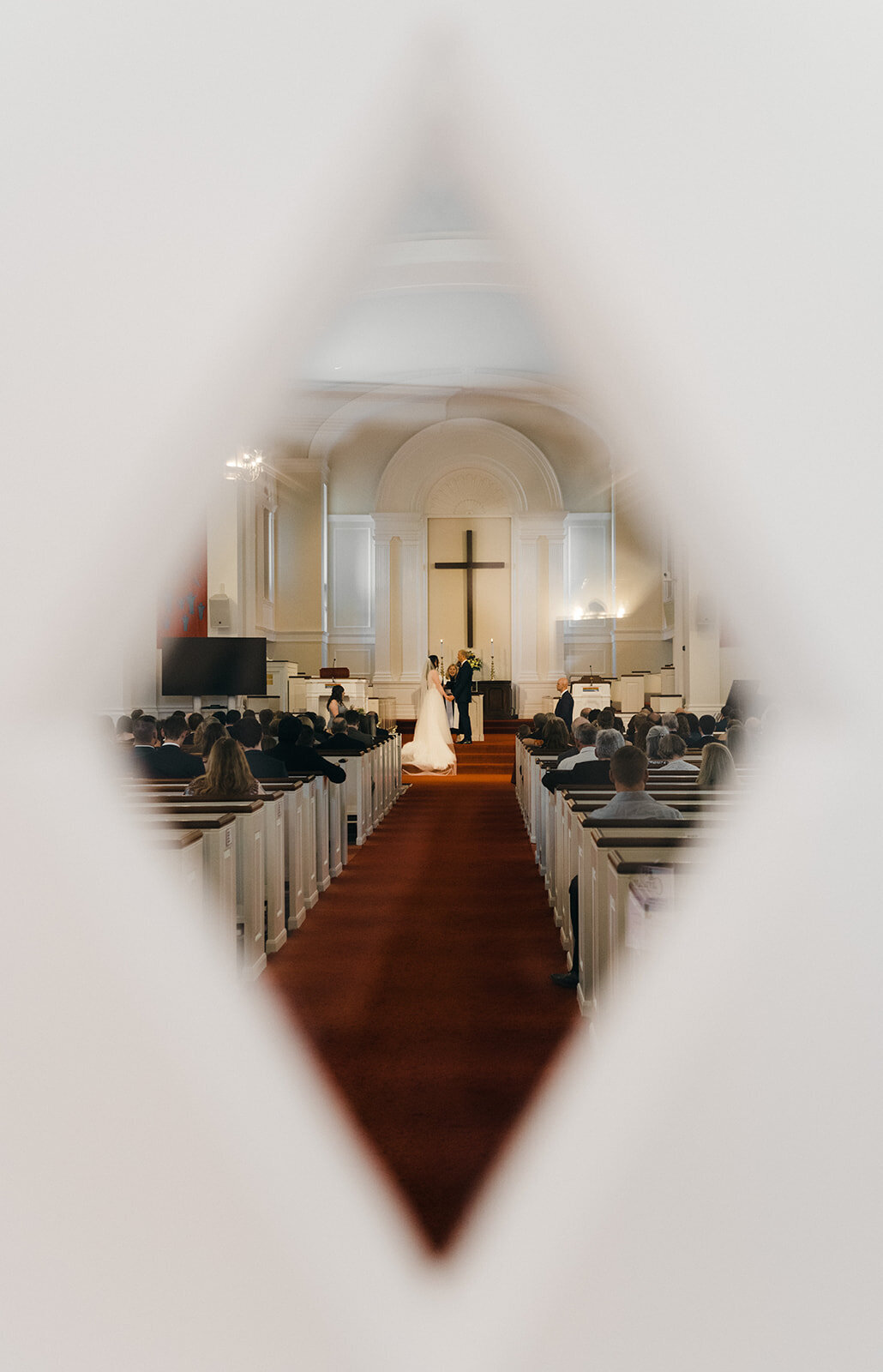 bride and groom stand at front of church altar during wedding in ct photo by cait fletcher photography
