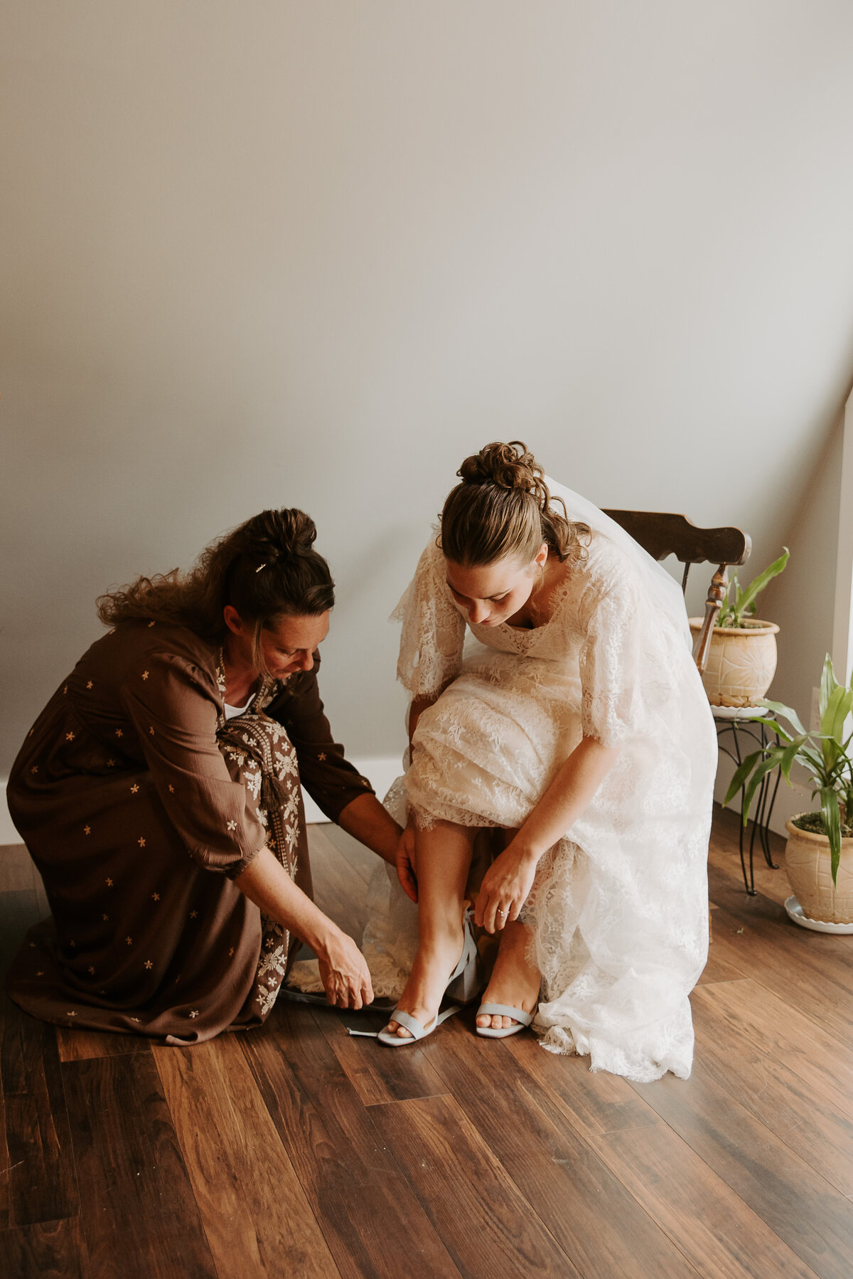 Getting ready photos with bride's mom helping her put on her shoes in an Airbnb outside of Mount Airy, North Carolina.